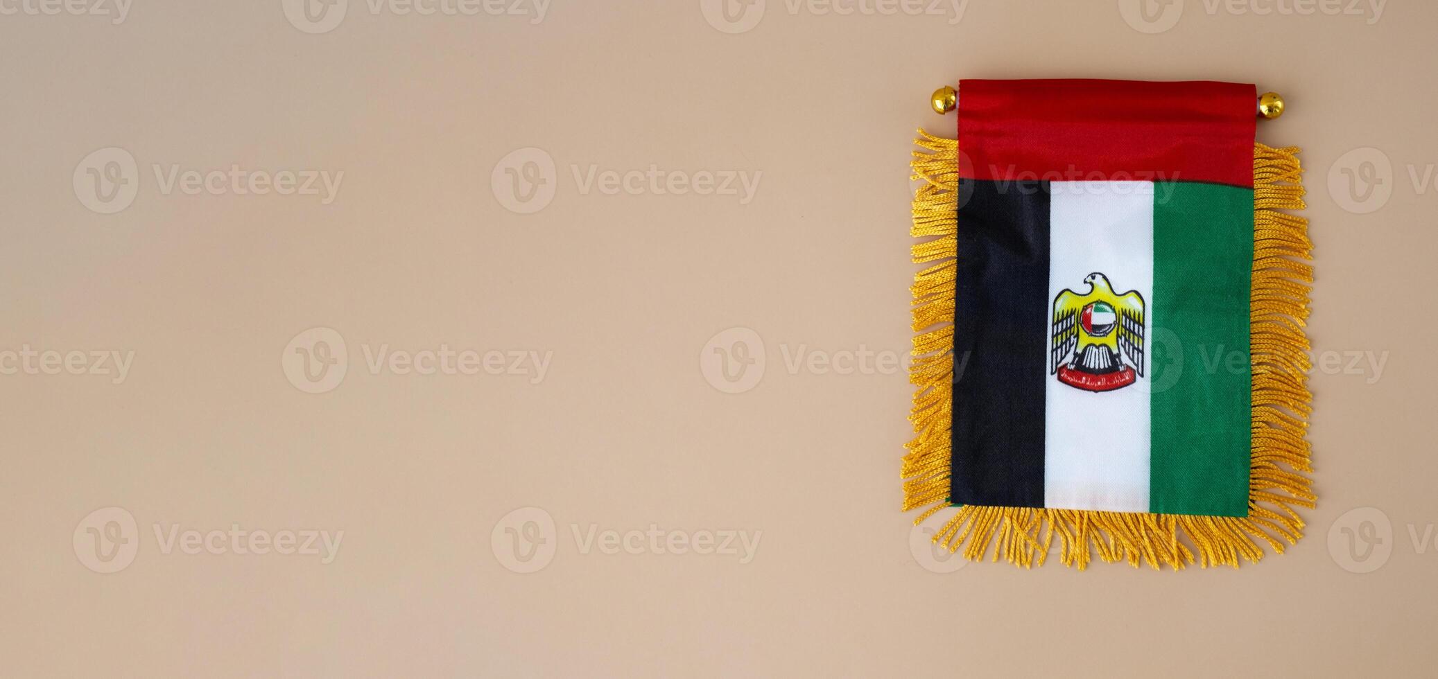 Small flag of UAE in beige background. Copy space. Mock up advertisement template. Tourism travel voucher with United Arab Emirates national symbol. Visit Dubai concept photo