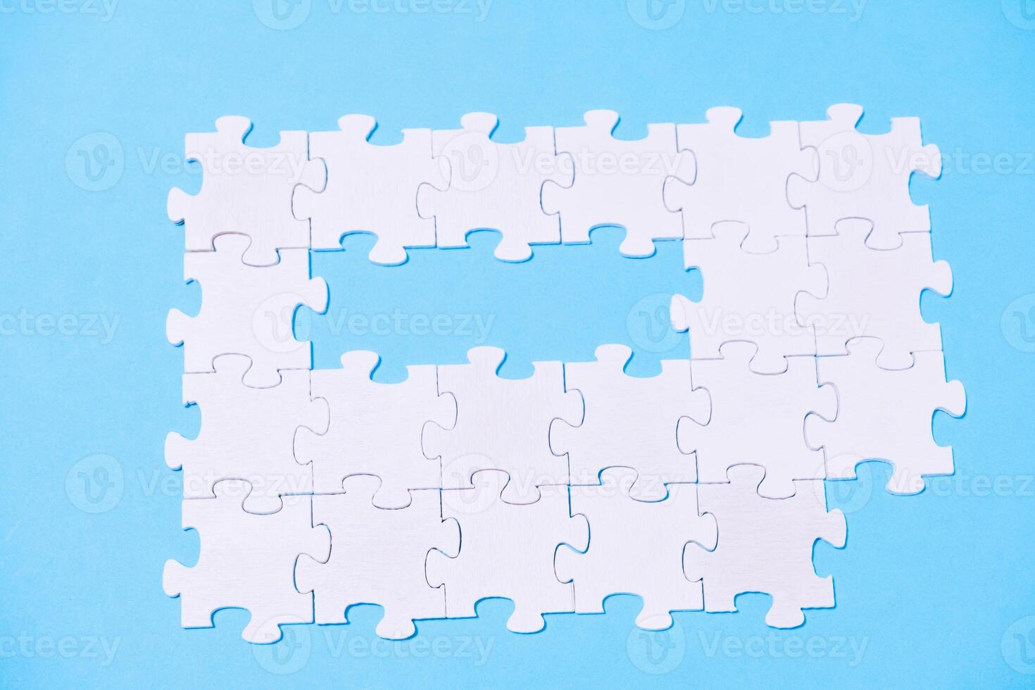 A puzzle with a missing piece is shown on a blue background photo