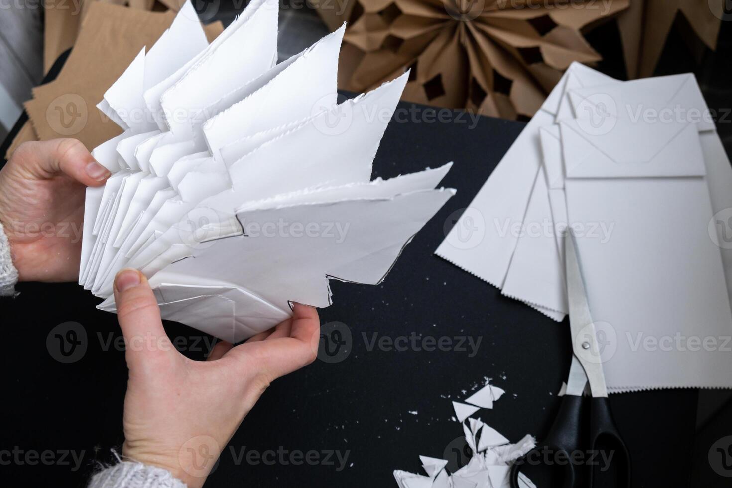 Master class of making craft paper snowflakes for conscientious Christmas decor. Sustainable celebration minimal responsible DIY holiday project. Step by step instruction photo