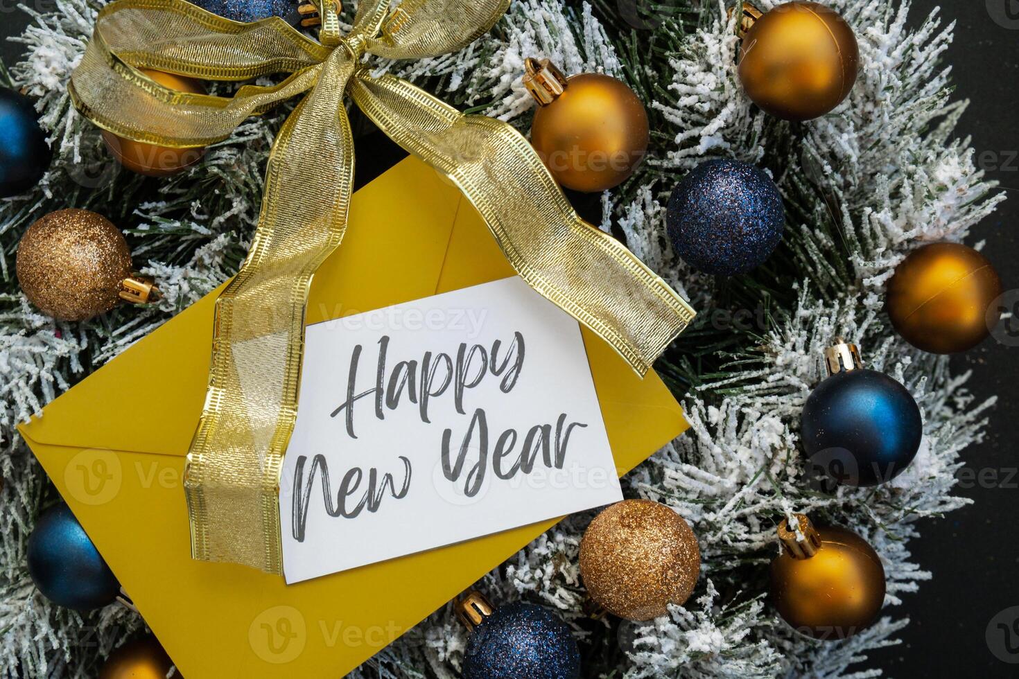 Christmas handmade wreath made of festive decorations with yellow envelope and paper note with HAPPY NEW YEAR text. Winter holiday celebration greeting card. top view photo