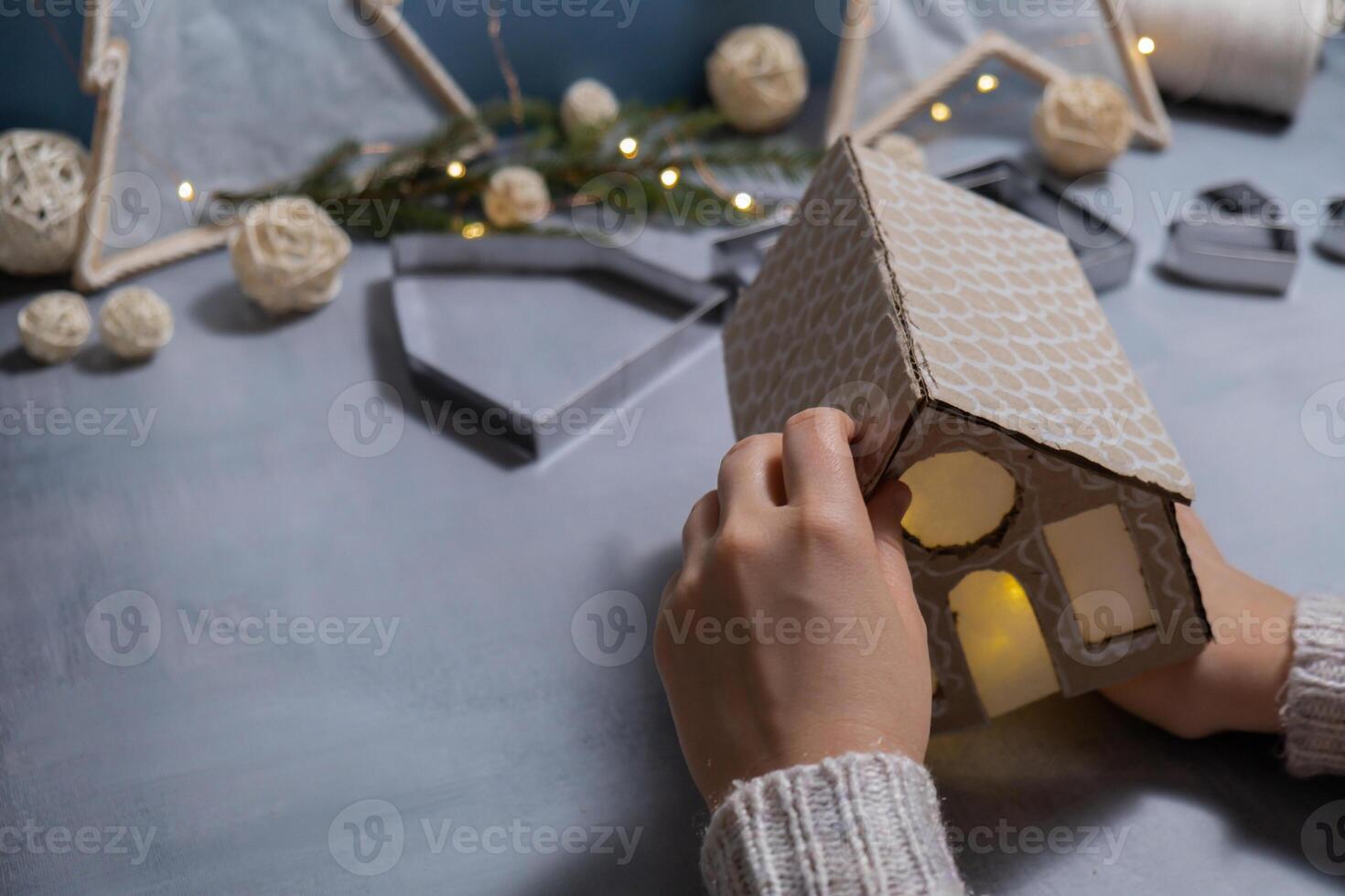 Cardboard Lantern handmade house Storytelling creating craft Christmas holiday decoration. Tactile hand-on activity. Master class progress of creative me-made gifts. Seasonal domestic life micro moment hobby. Sustainable living photo