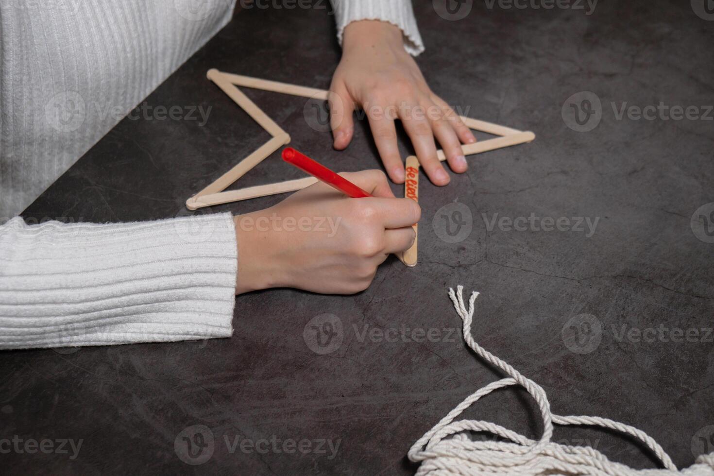 Christmas star ice cream sticks handmade Storytelling creating craft Christmas holiday decoration. Tactile hand-on activity. Master class progress of creative me-made gifts. Seasonal domestic life micro moment hobby. Sustainable living photo