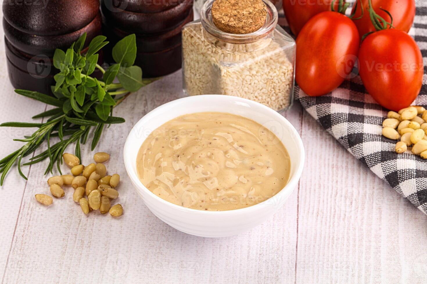 A bowl of mustard and a bowl of tomatoes photo