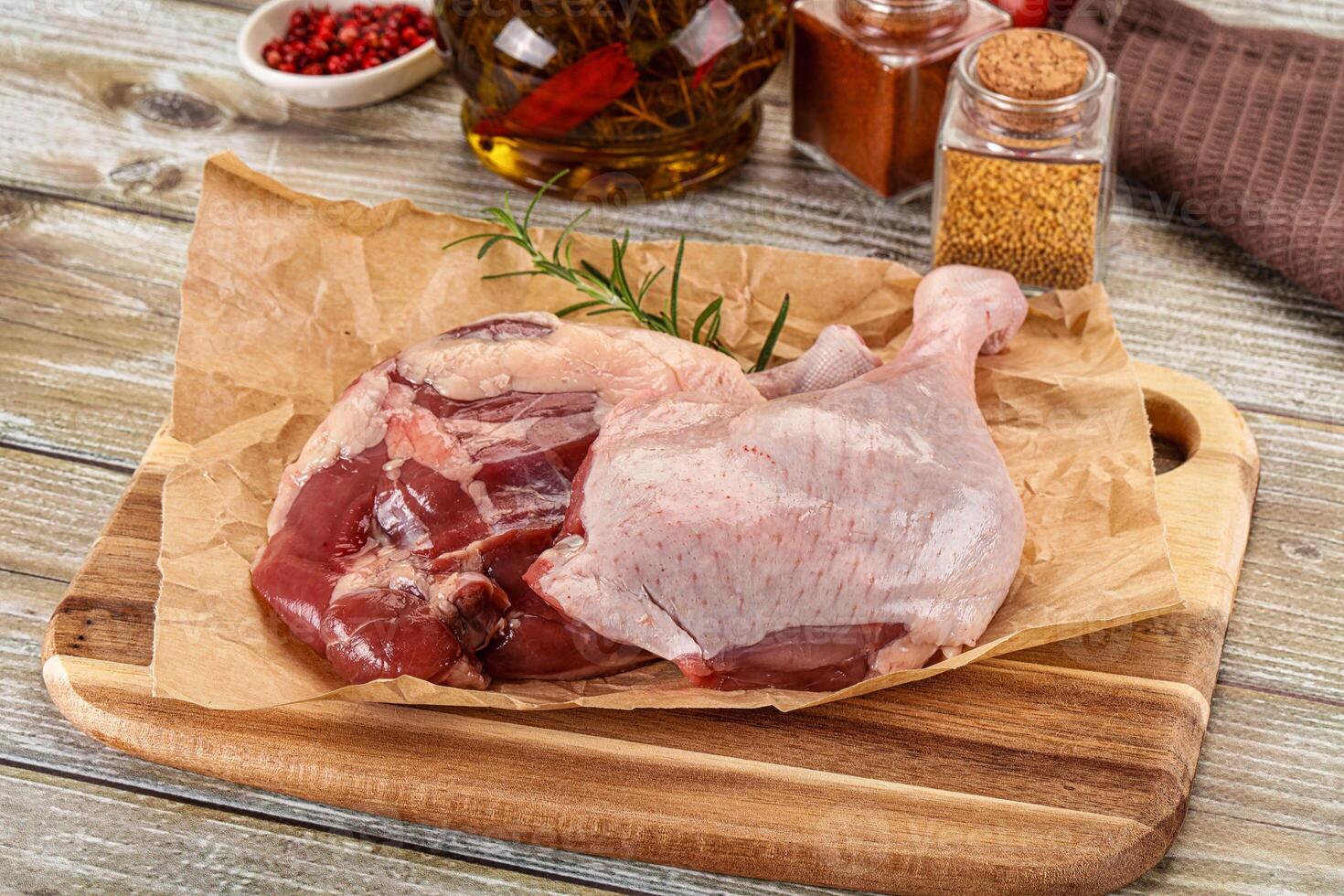 Raw chicken on a cutting board with spices and herbs photo