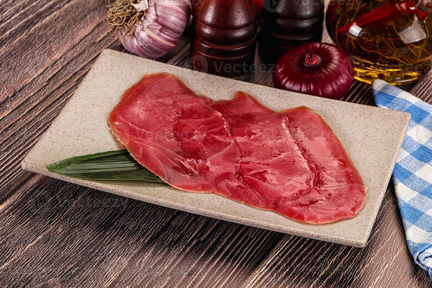 A plate with meat and vegetables on a wooden table photo