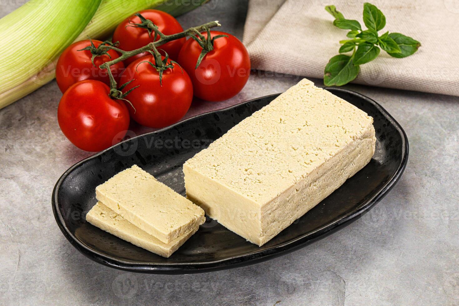 A plate of food with a piece of cheese and tomatoes photo