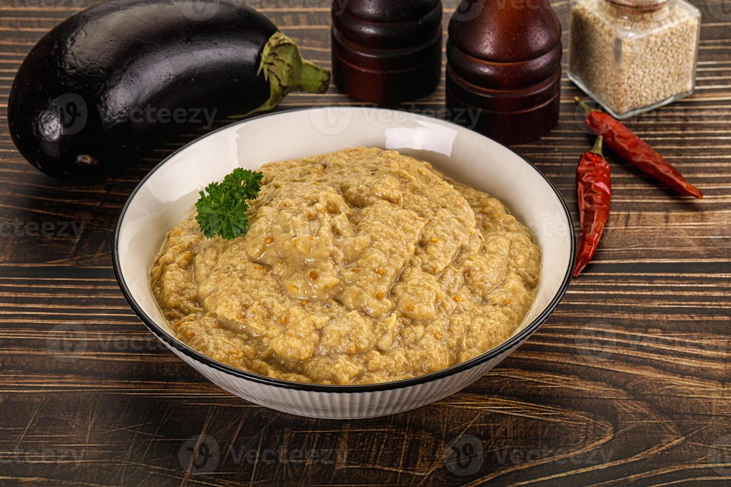 A bowl of hummus with a spoon and some spices photo