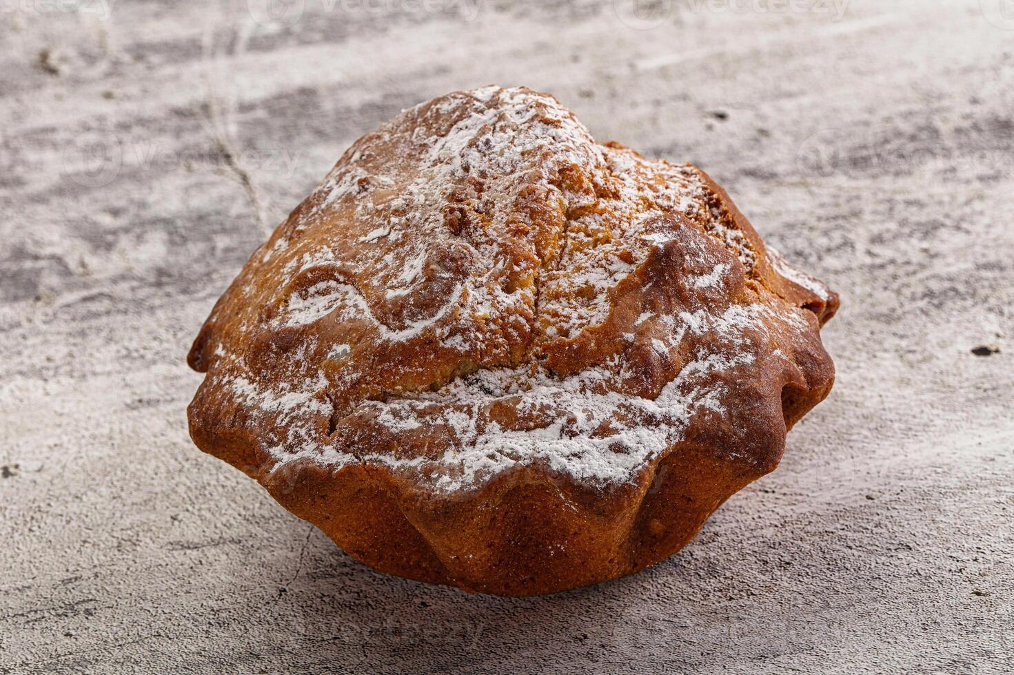 A muffin with powdered sugar on top photo