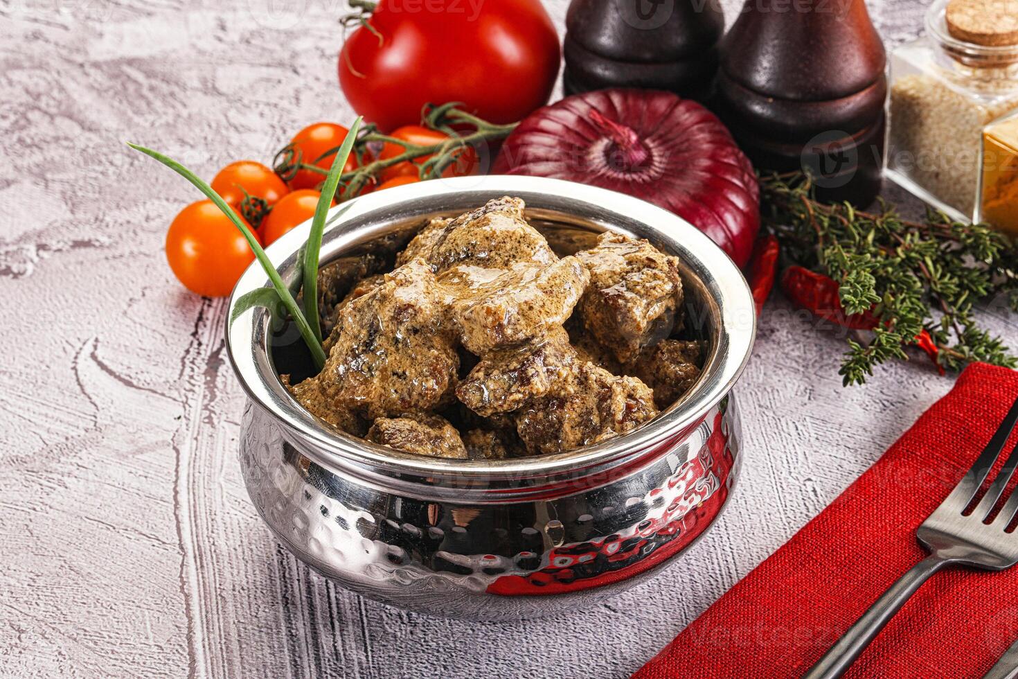 A silver bowl filled with meat and vegetables photo