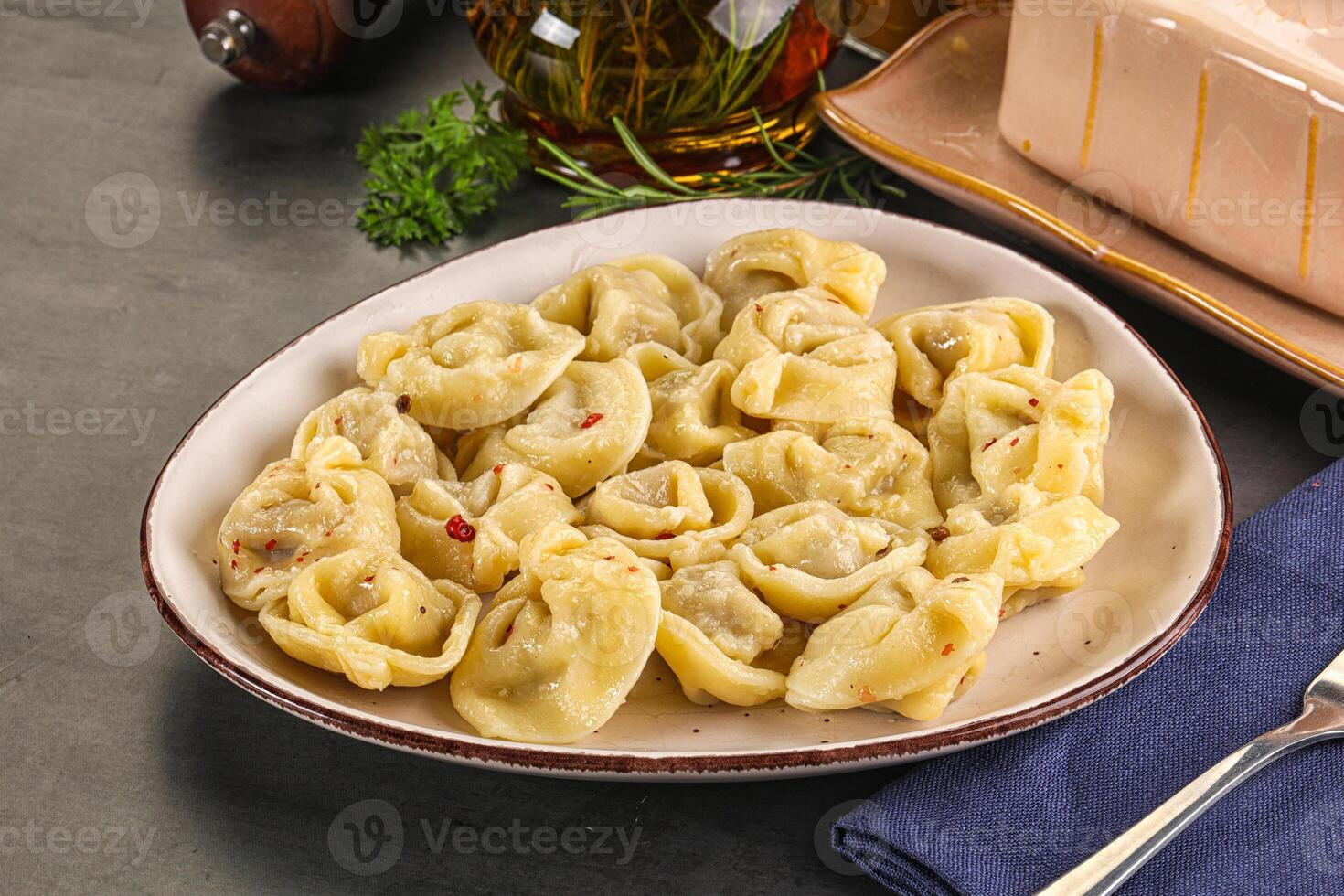 A plate of pasta with a fork and knife on a table photo