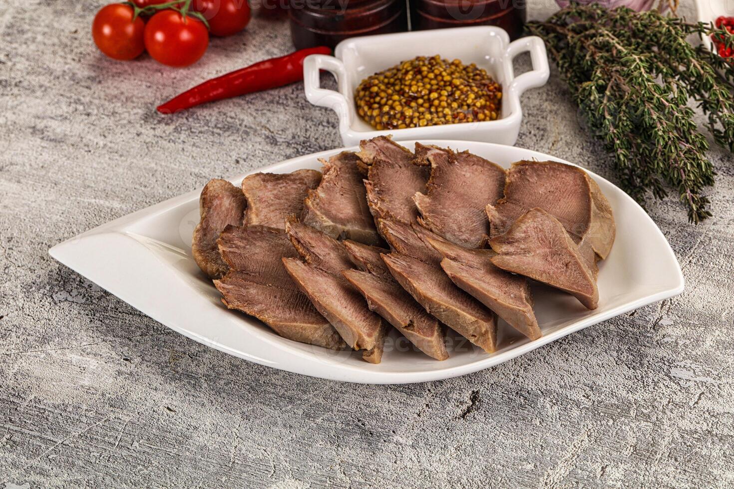 A plate of meat on a table with other ingredients photo