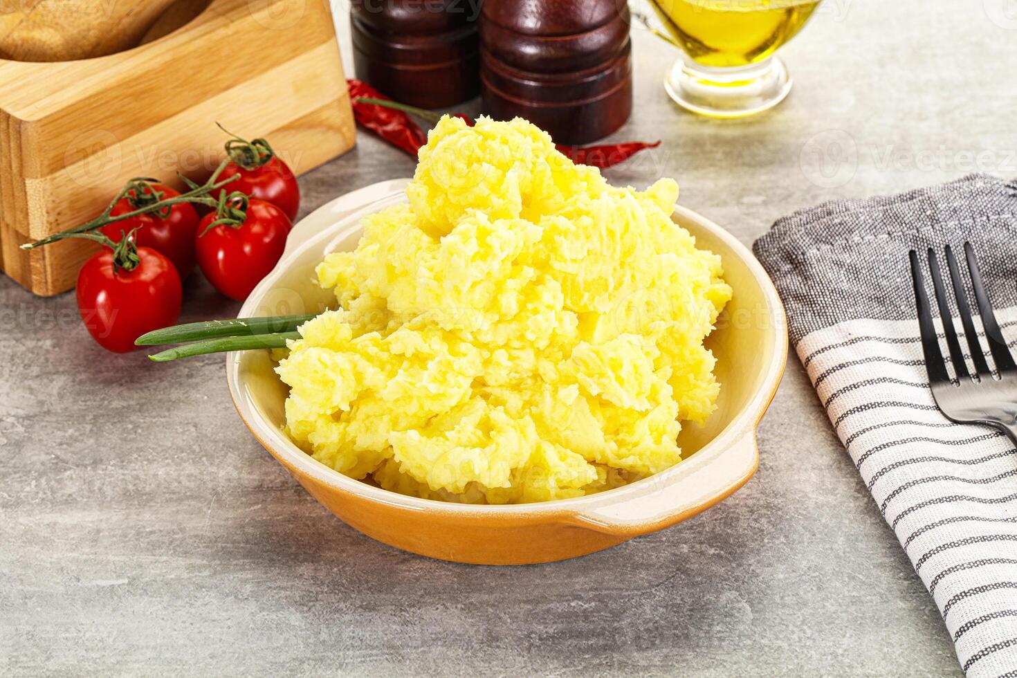 A bowl of mashed potatoes with a knife and fork photo