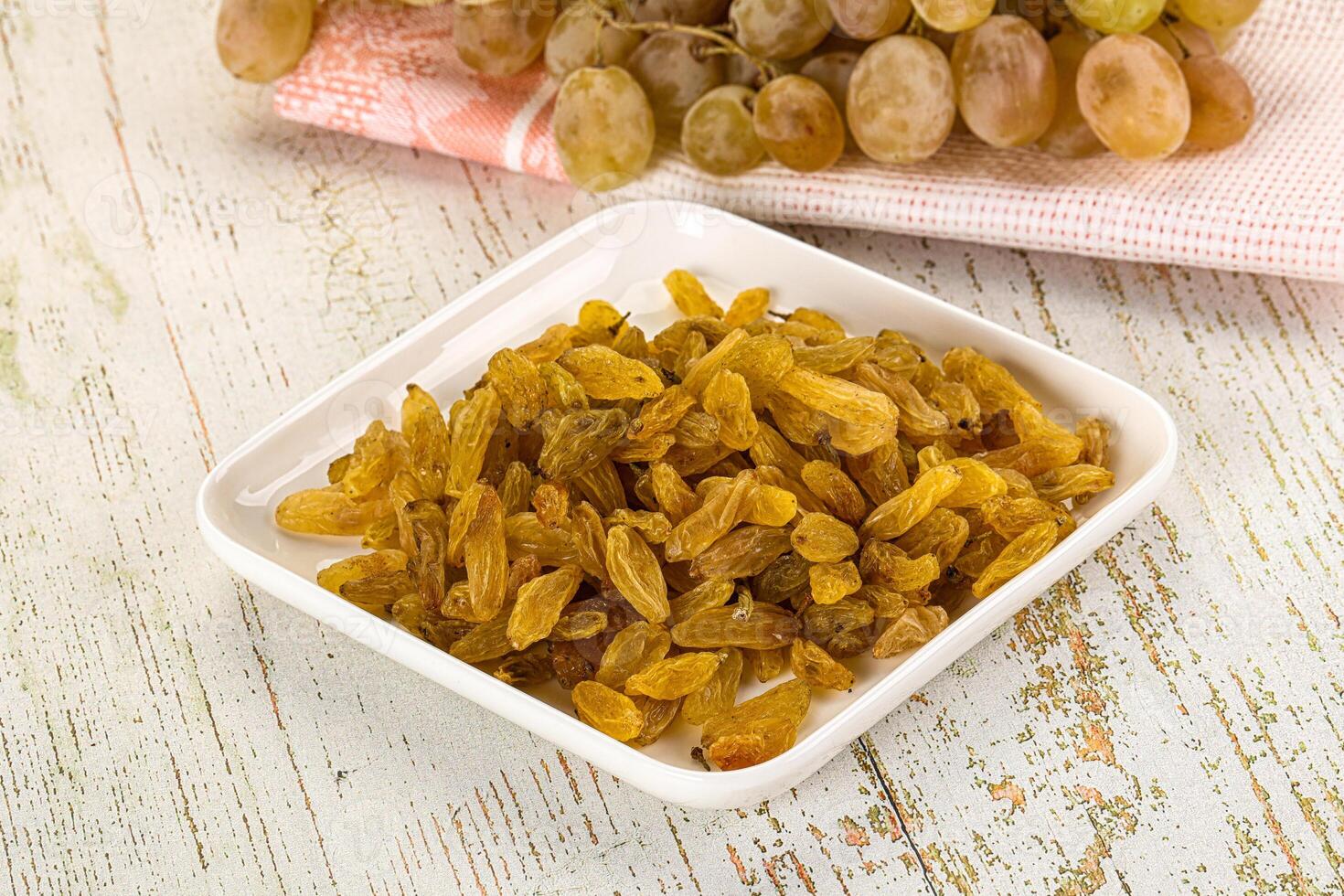 A bowl of grapes and a bowl of raisins photo