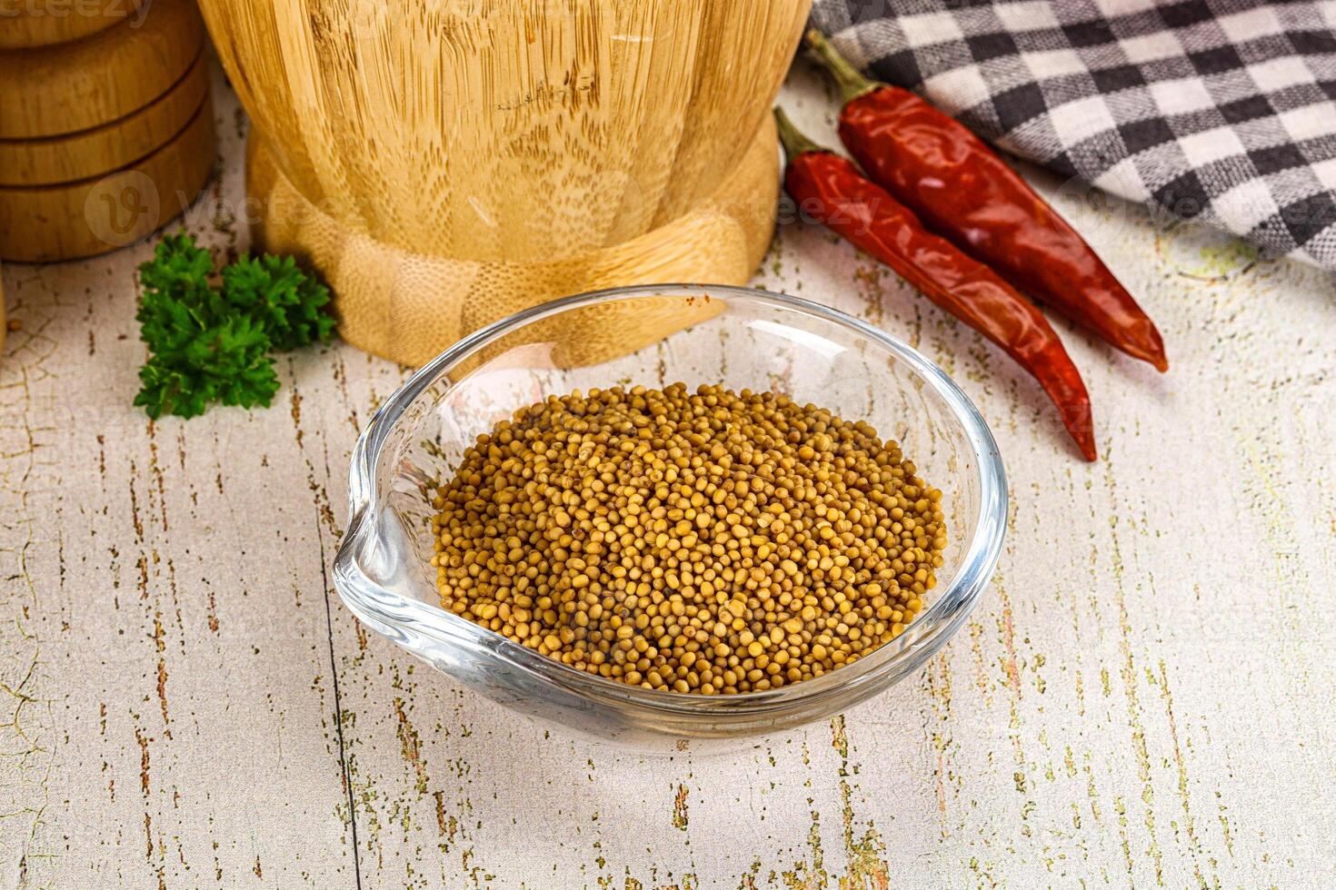 A bowl of mustard seeds and a wooden cutting board photo