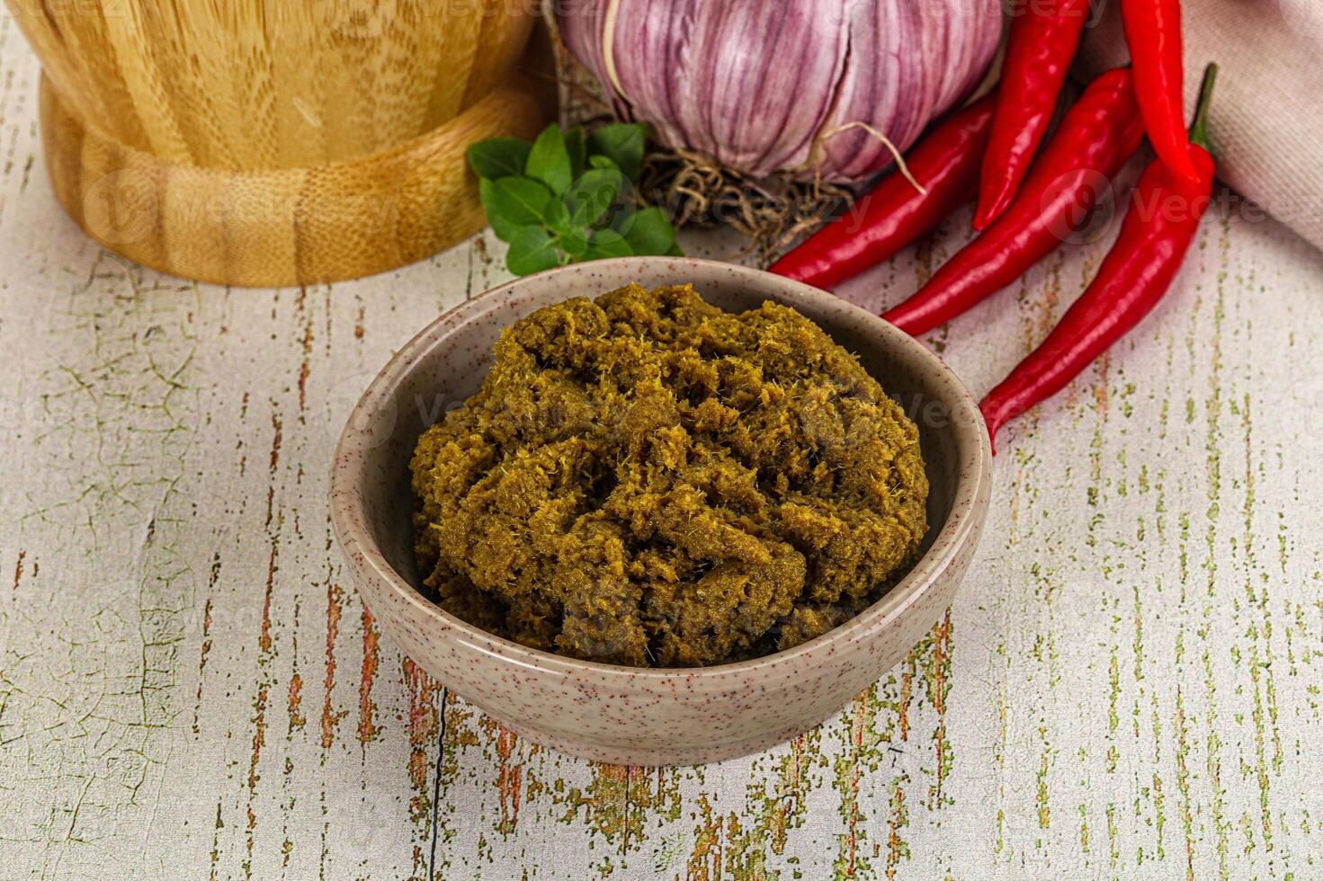 A bowl of green curry paste with red peppers and garlic photo
