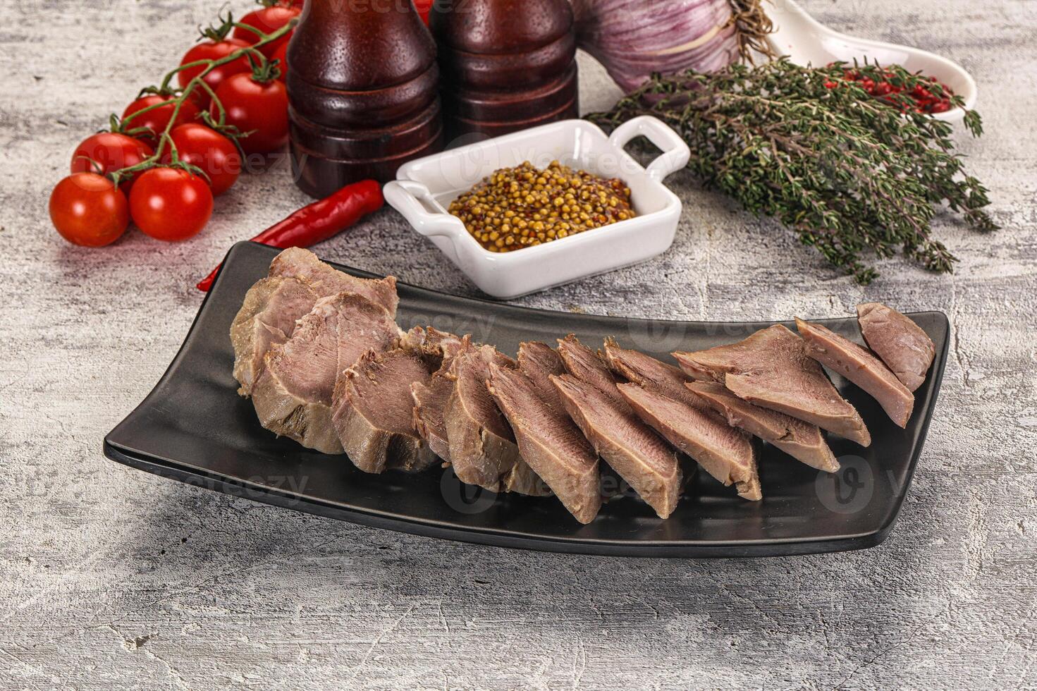 A plate of meat with vegetables and spices on a table photo