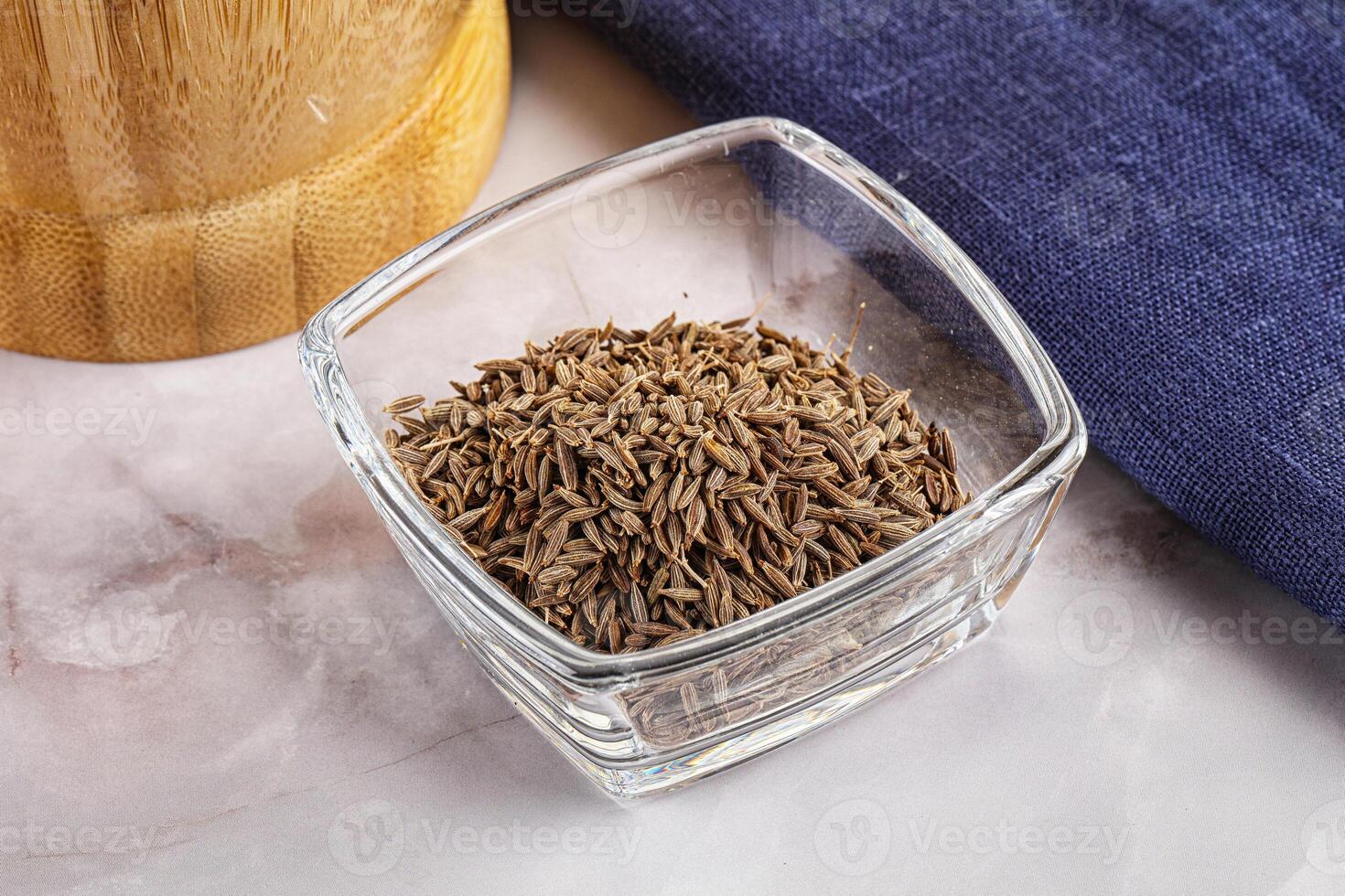 A bowl of seeds and a wooden spoon photo