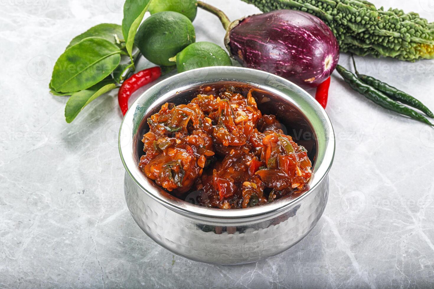 A silver container filled with vegetables and spices photo