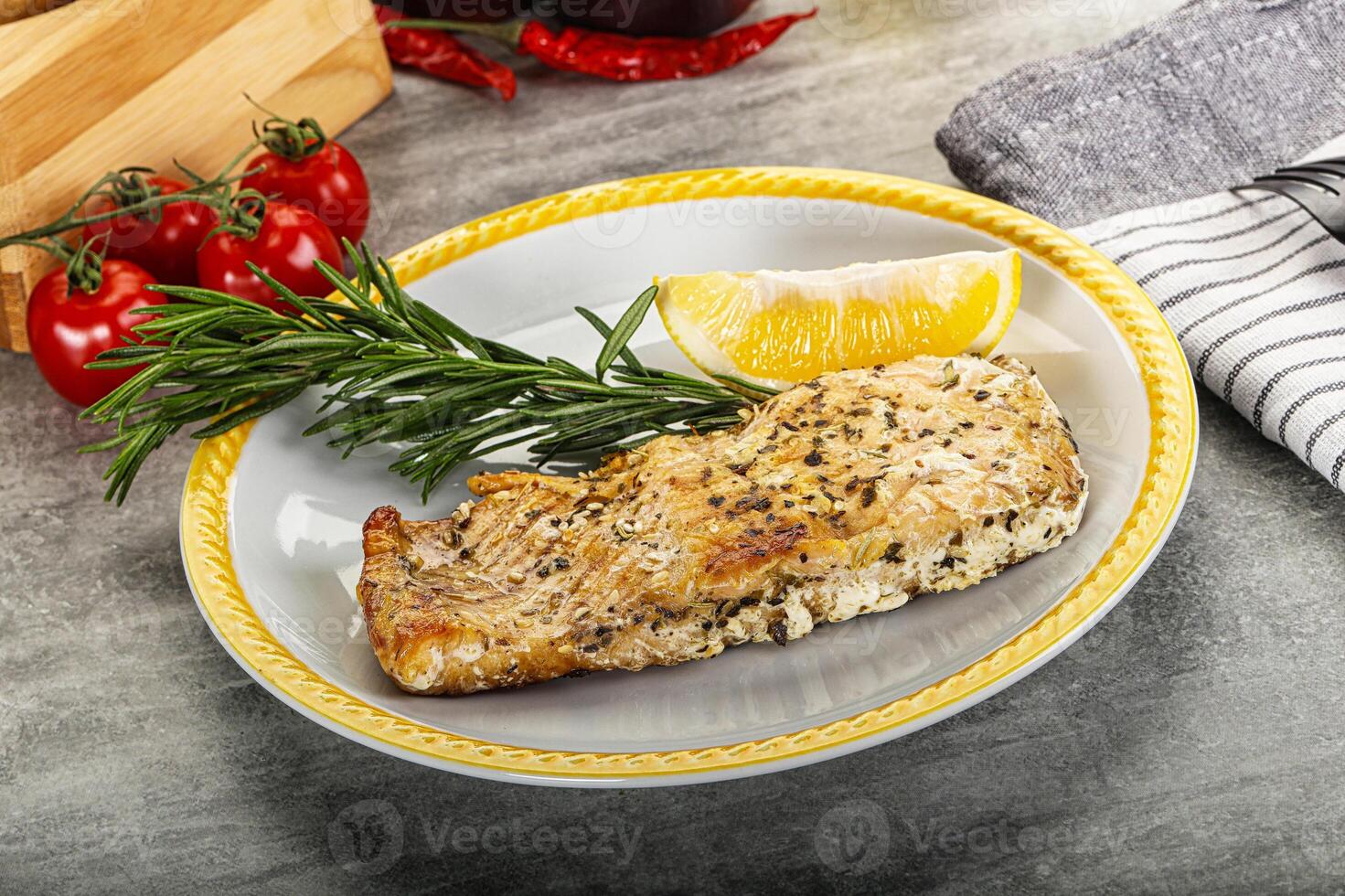 A plate of food with a lemon and a rosemary sprig photo