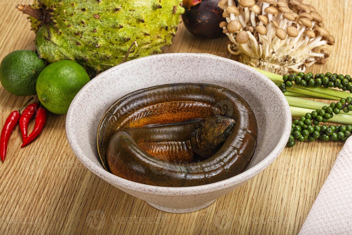 A bowl of worms sitting on a table next to a bowl of fruit photo