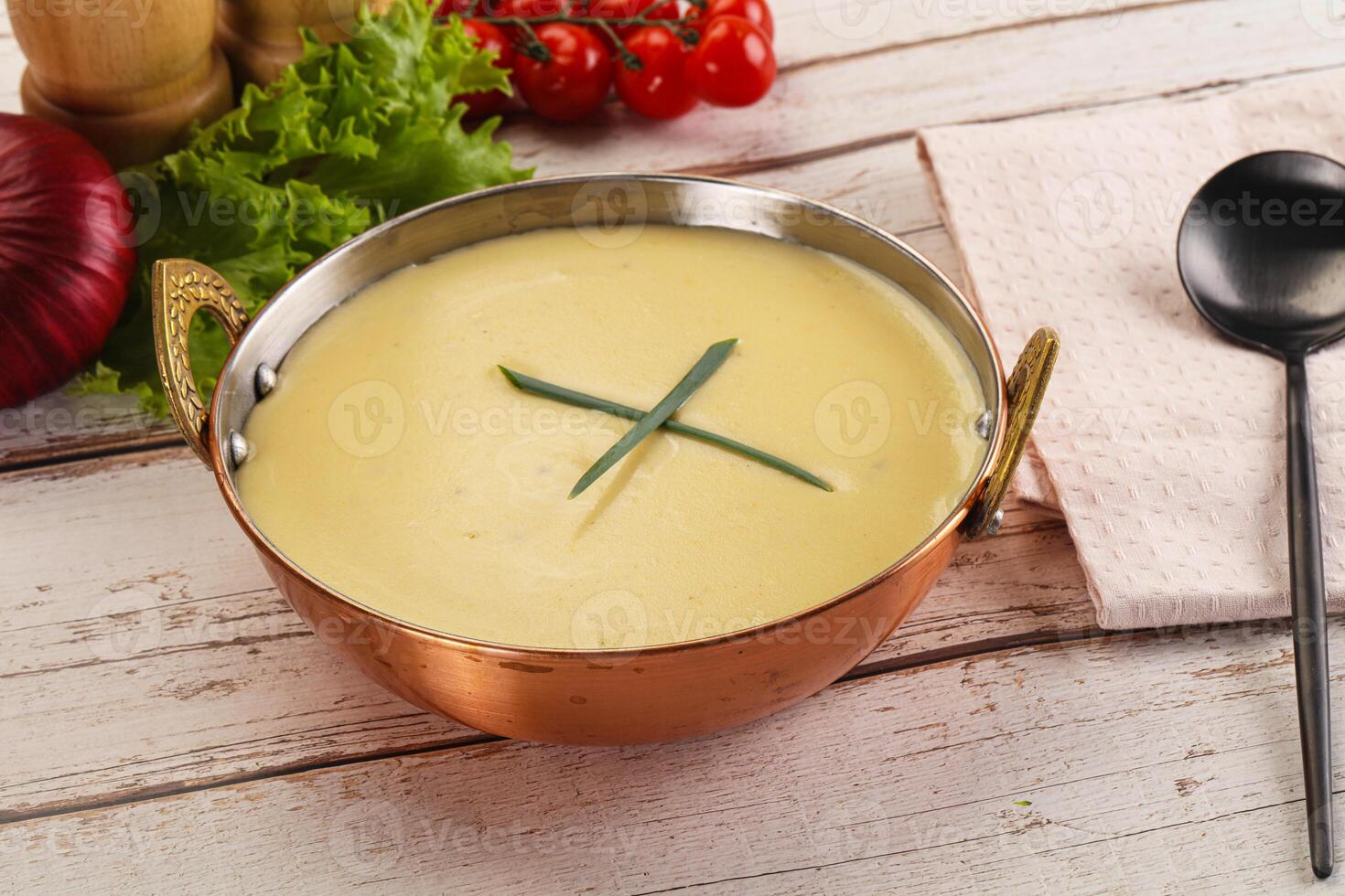 A bowl of soup with a spoon and a knife photo