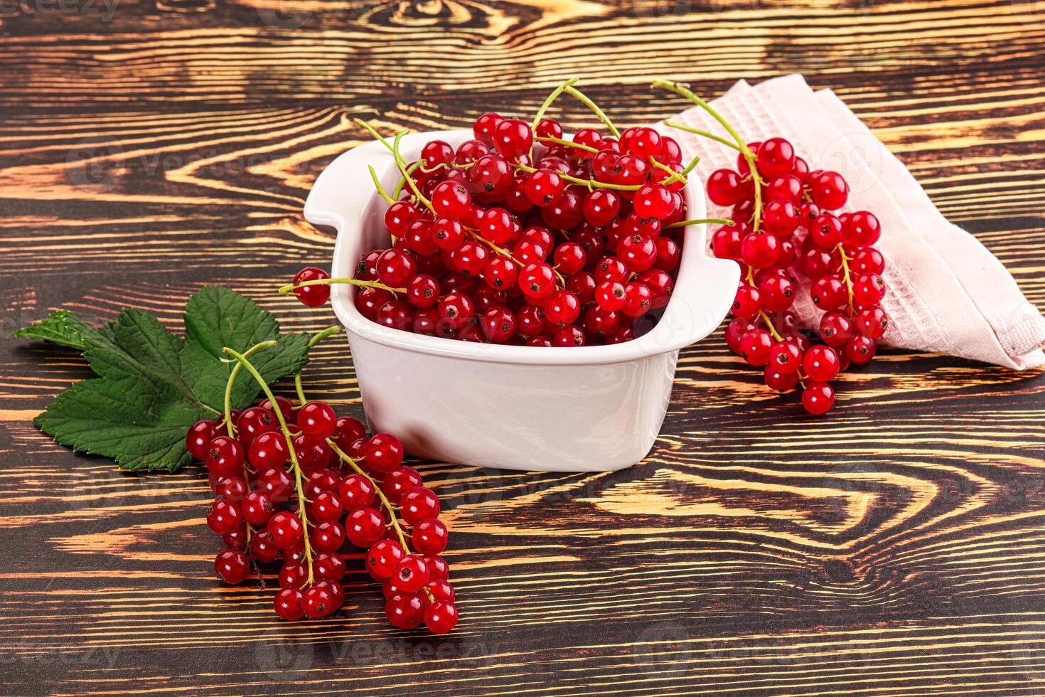 A bowl of red currants on a table photo