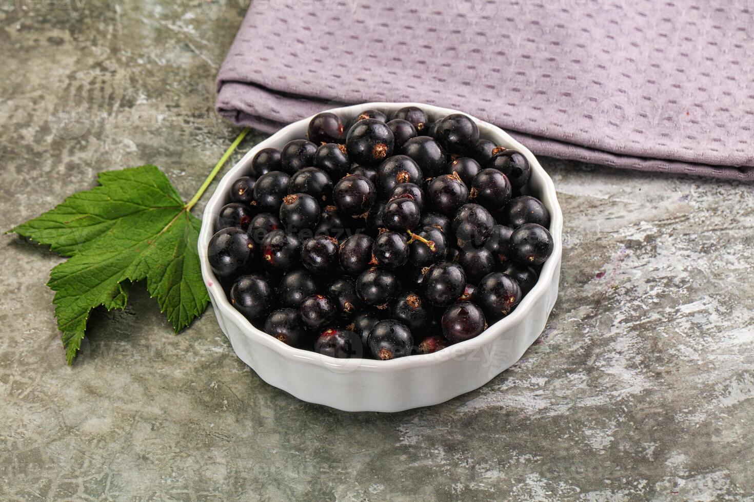 Black currant in a bowl on a table photo