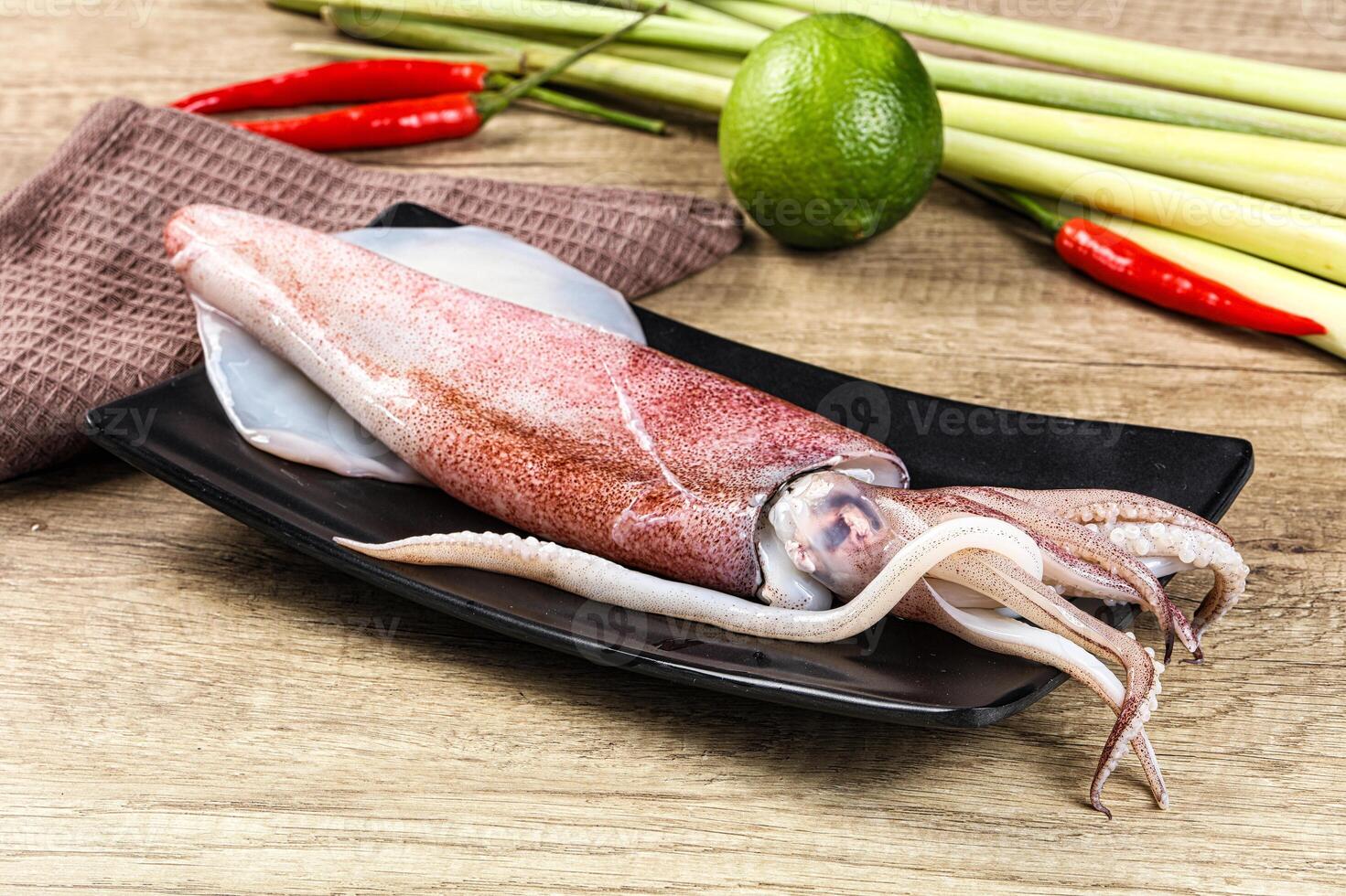 A squid on a plate with a knife and some other vegetables photo
