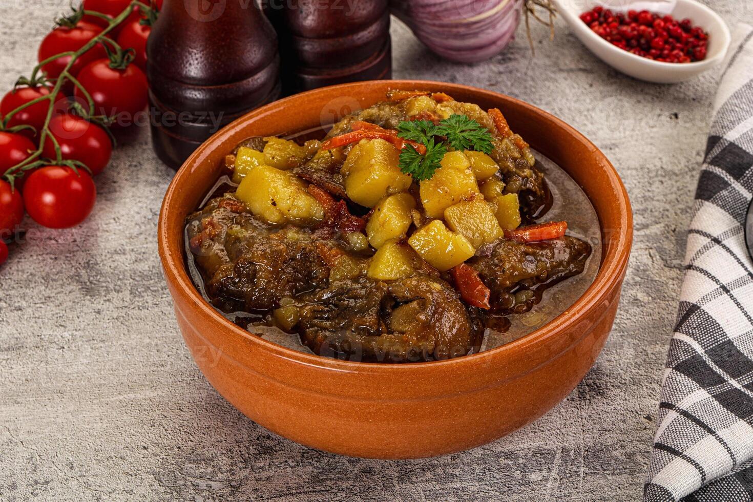 A bowl of stew with vegetables and tomatoes photo