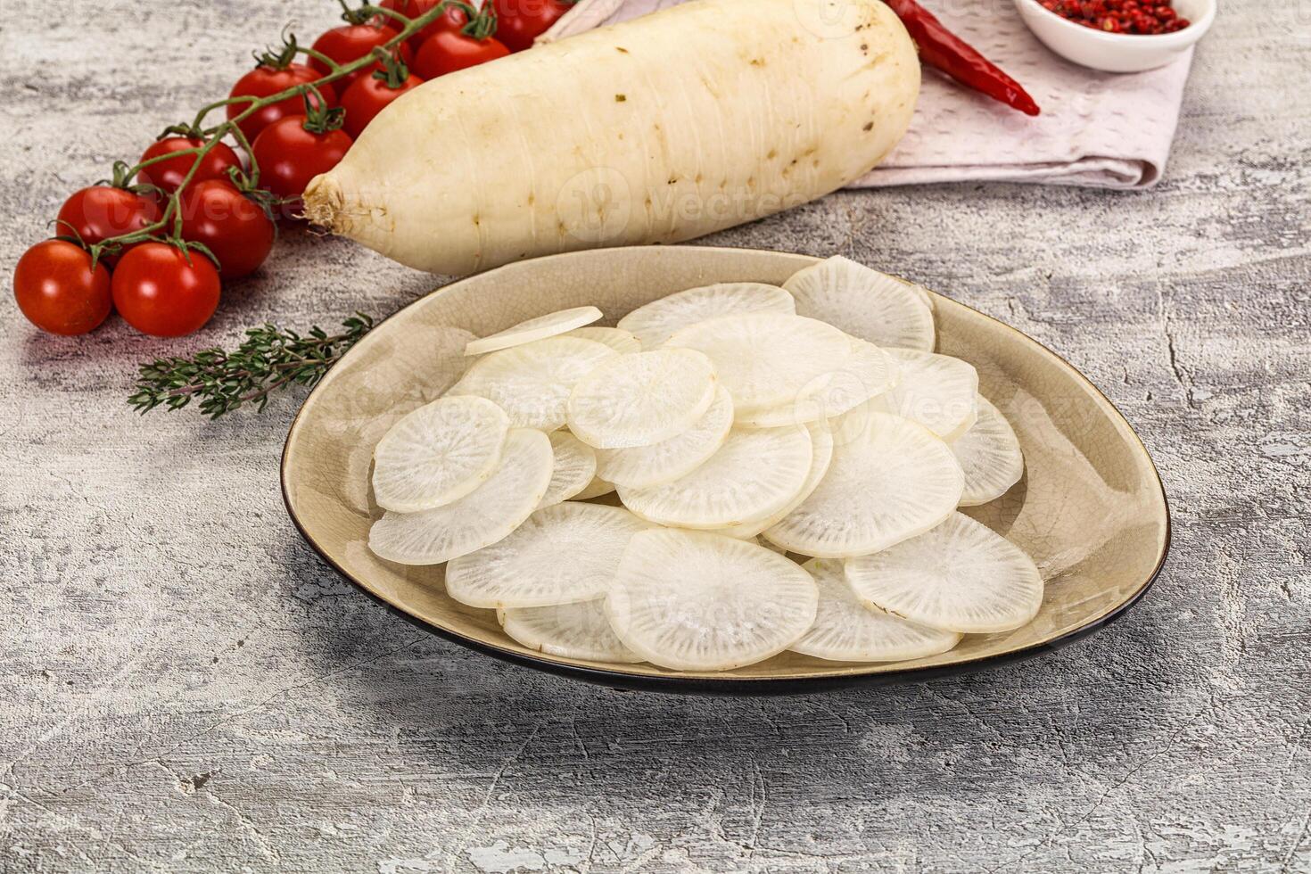 A bowl of sliced radishes and tomatoes on a table photo