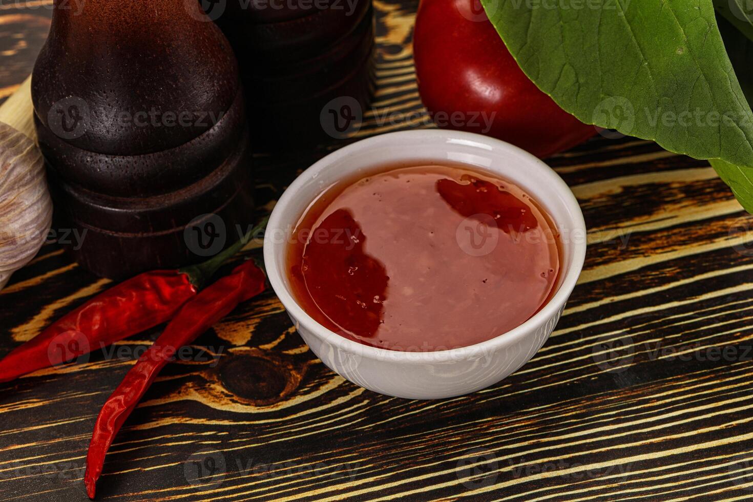 A bowl of sauce next to a bottle of sauce photo