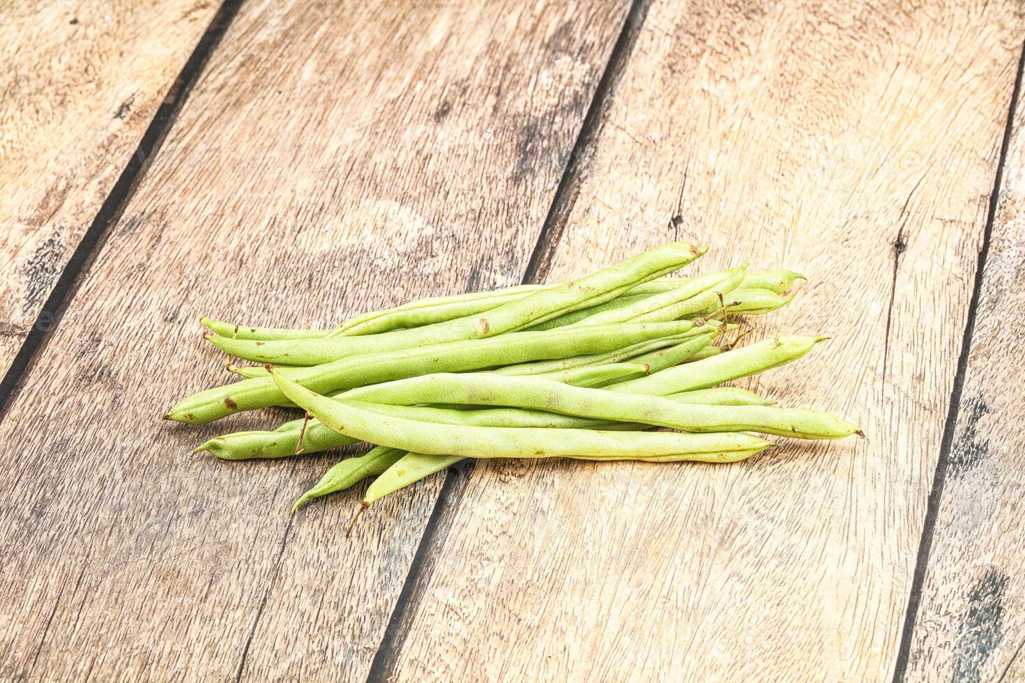 Fresh green beans on wooden table photo