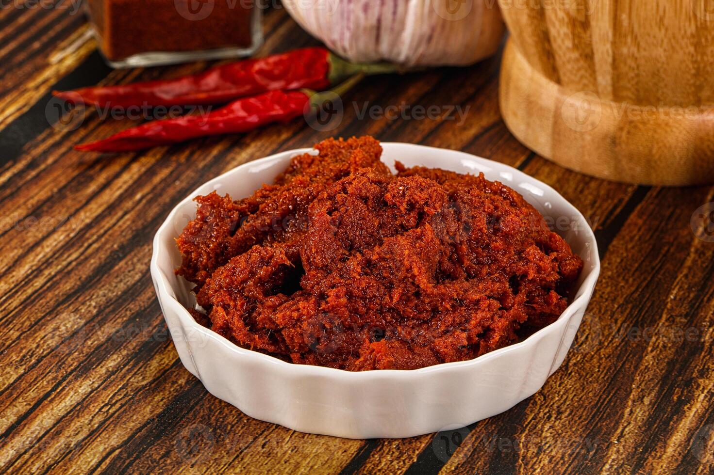 A bowl of red chili paste on a table photo