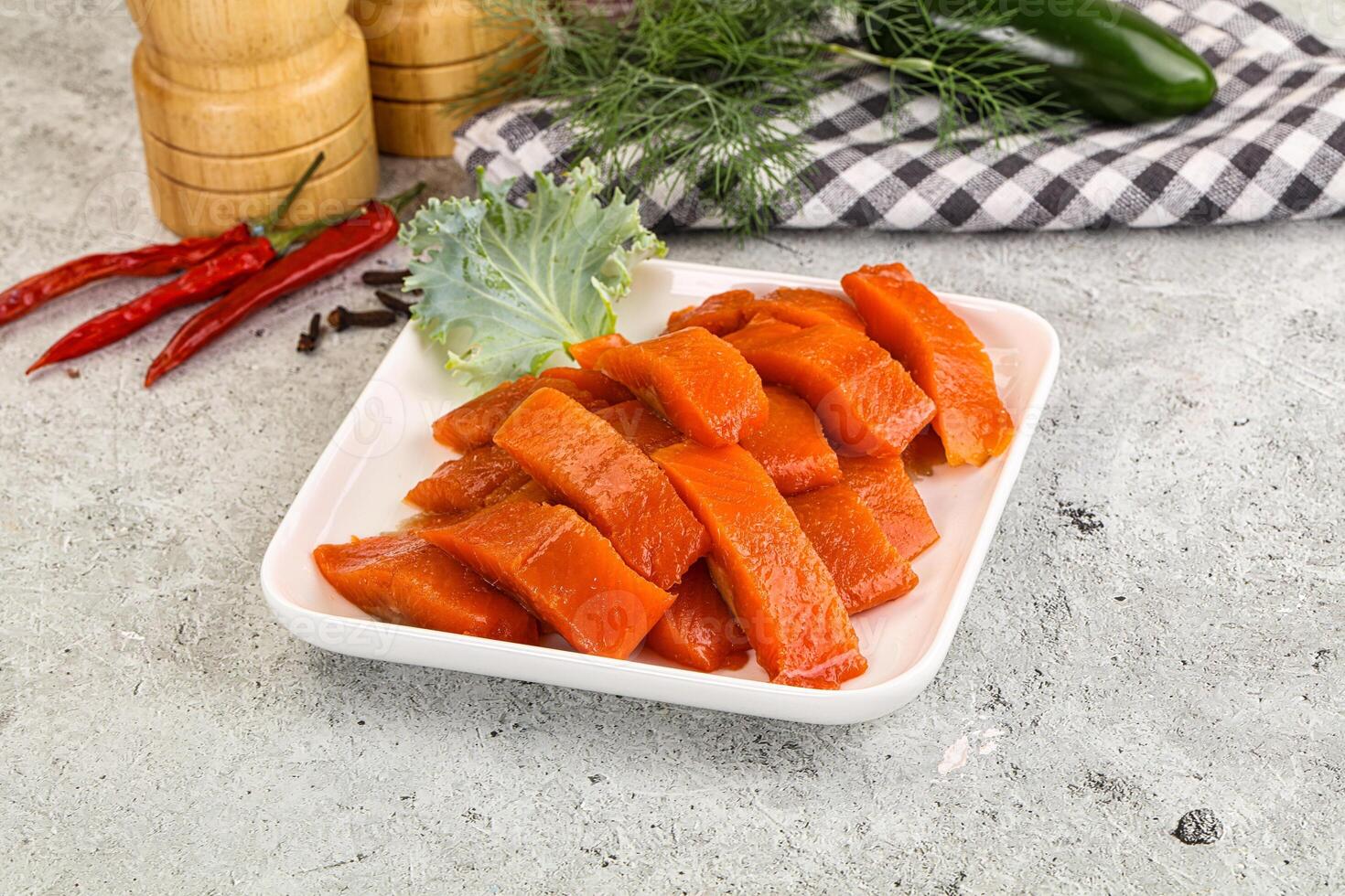 A plate of cooked salmon with vegetables on a table photo
