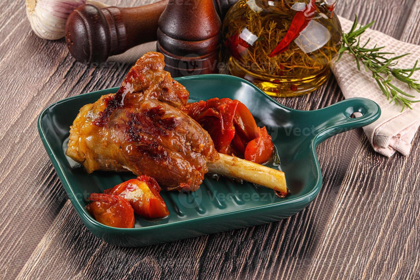 A plate with a chicken leg and some vegetables photo
