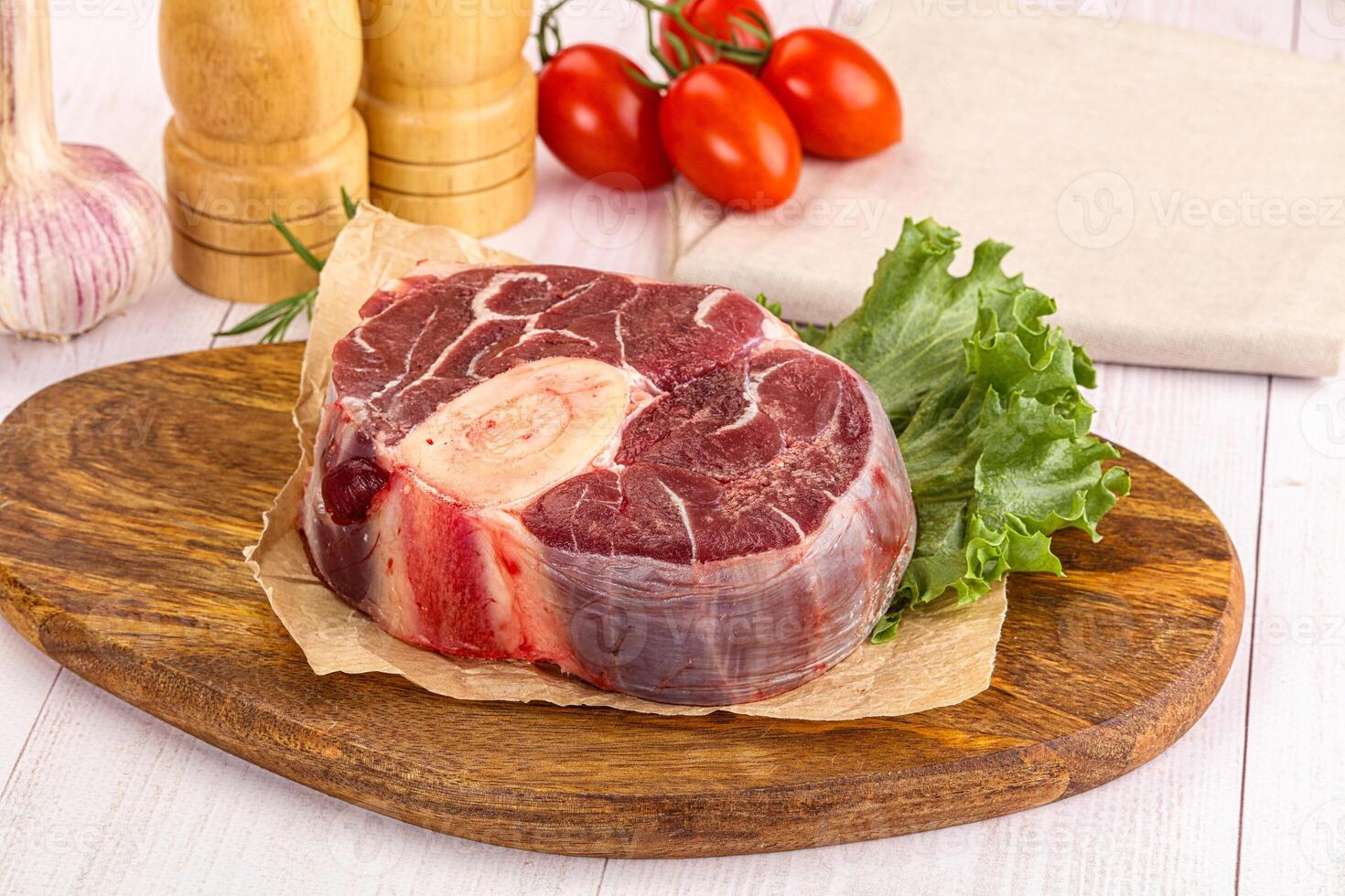 A piece of meat on a cutting board with a knife photo