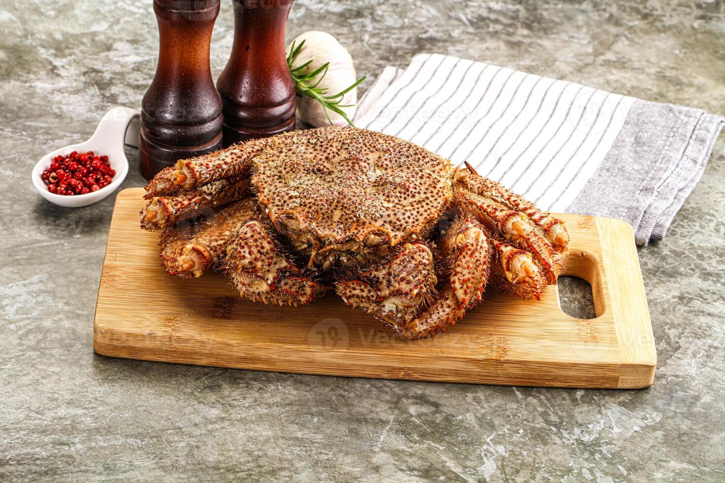 A crab on a cutting board with spices photo
