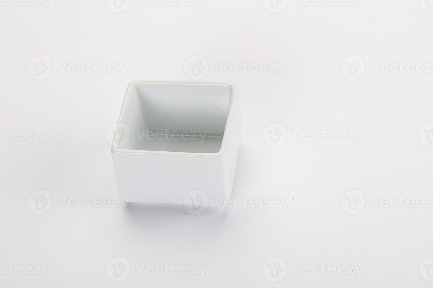 A white square container with a lid on a white surface photo