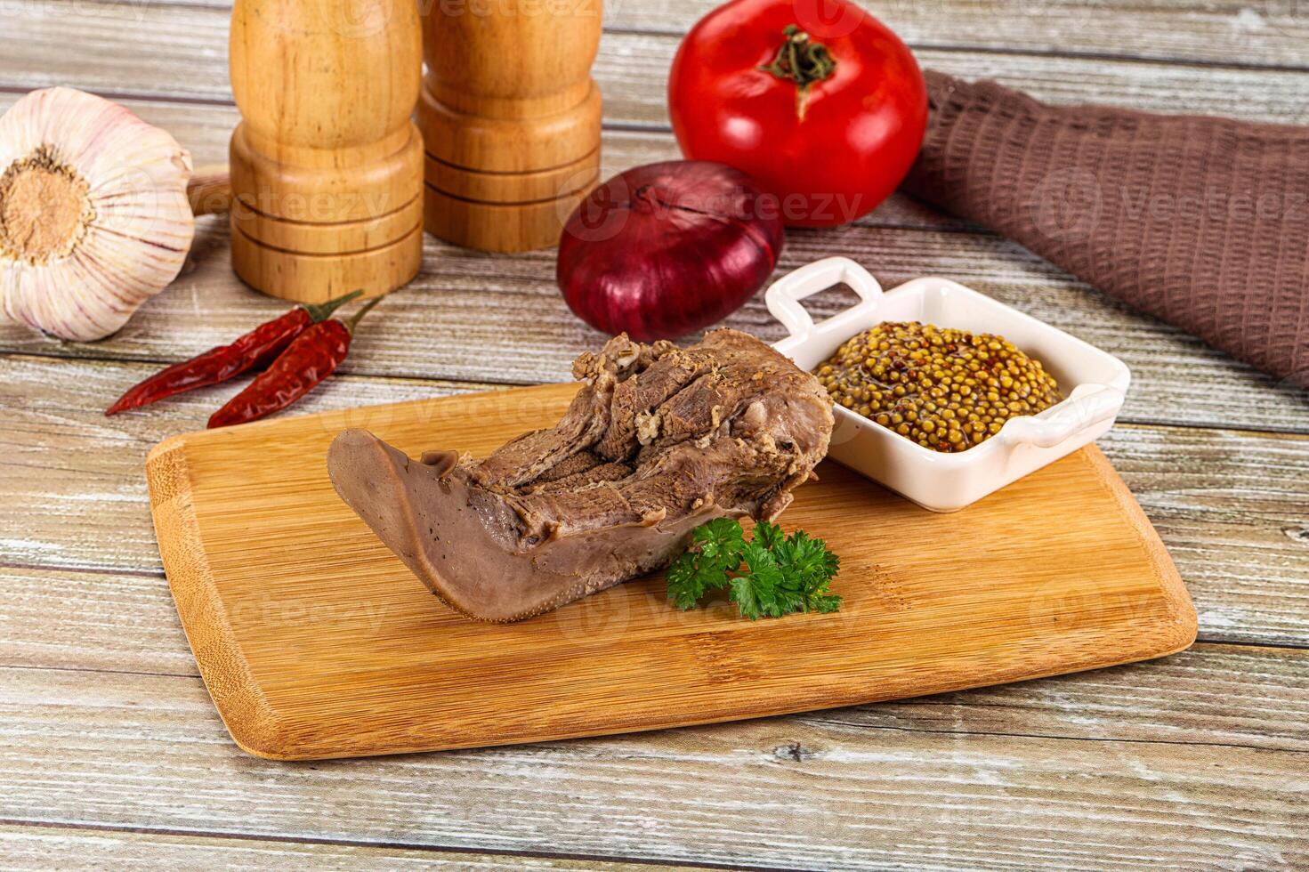 A wooden cutting board with meat, spices and vegetables photo