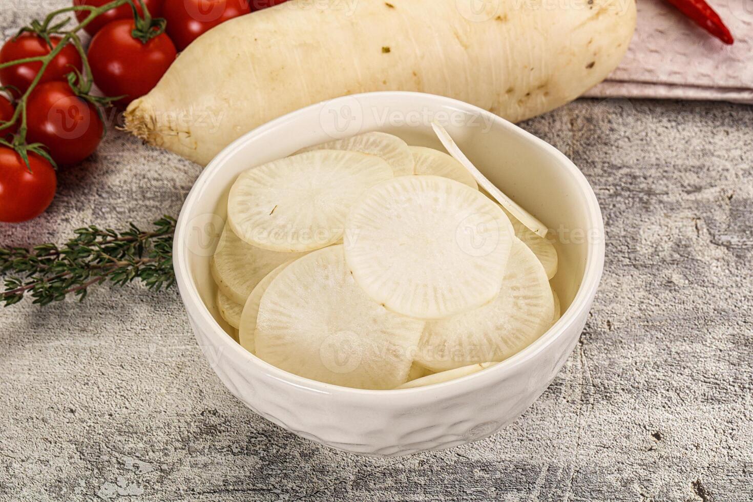 A bowl of sliced vegetables and a bowl of tomatoes photo
