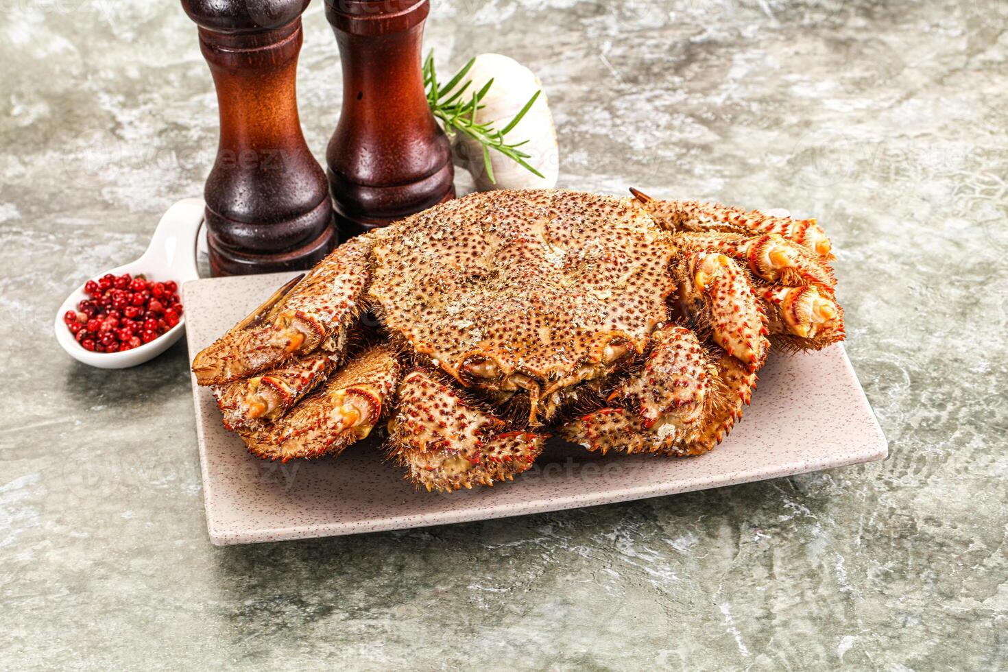 A crab on a plate with salt and pepper photo