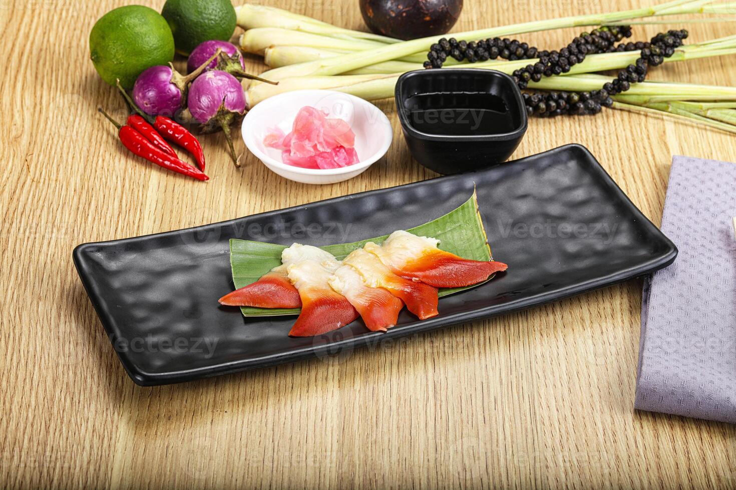 A black rectangular plate with a piece of sushi on it photo