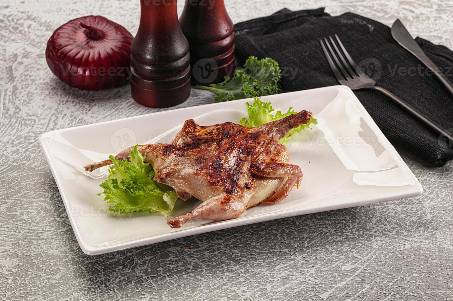 A plate with a chicken on it and a knife and fork photo
