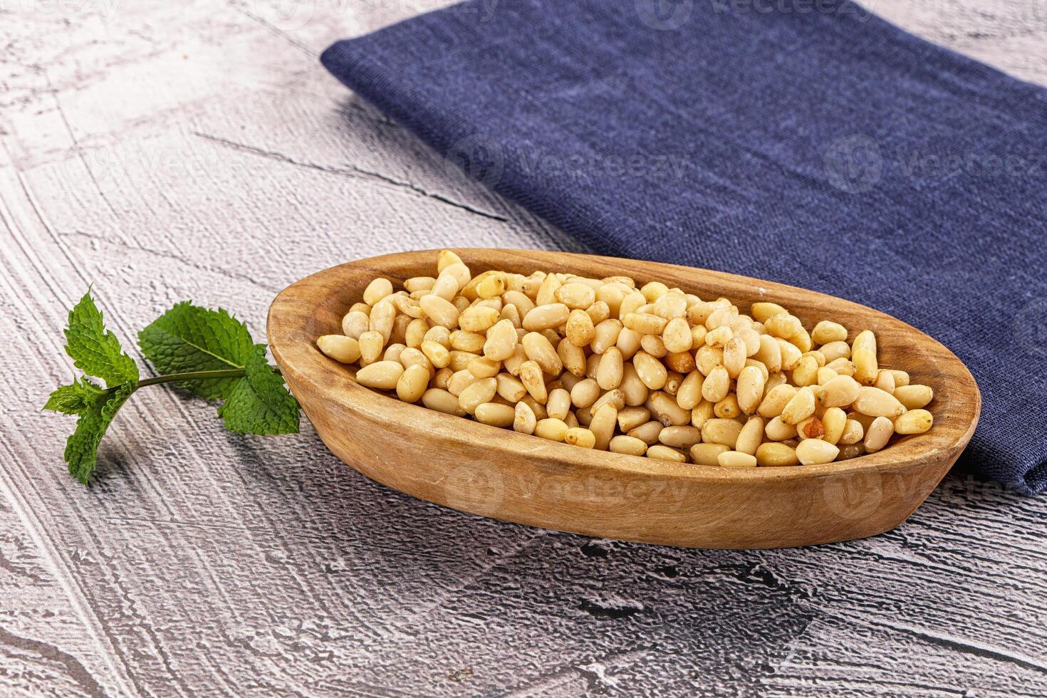 A wooden bowl filled with nuts and a napkin photo
