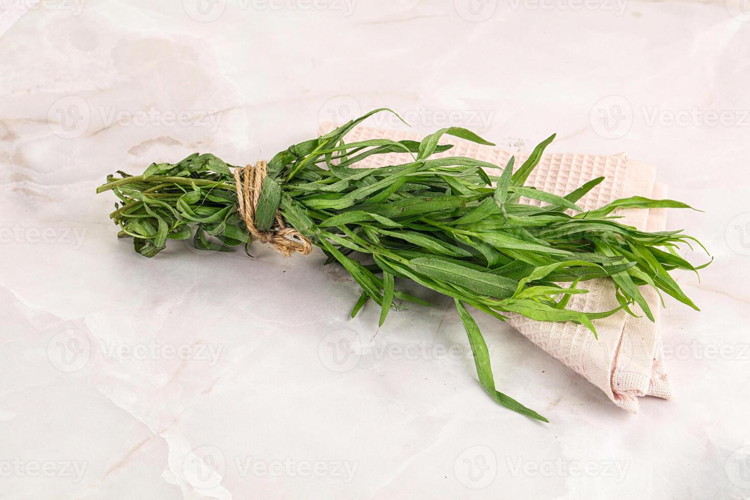 A bunch of herbs on a white marble surface photo