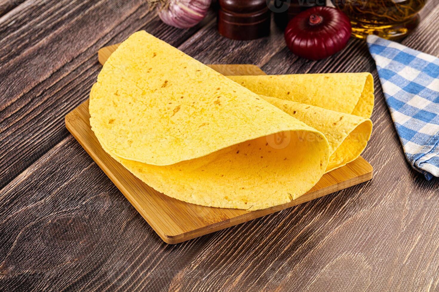 A tortilla on a cutting board with some spices photo
