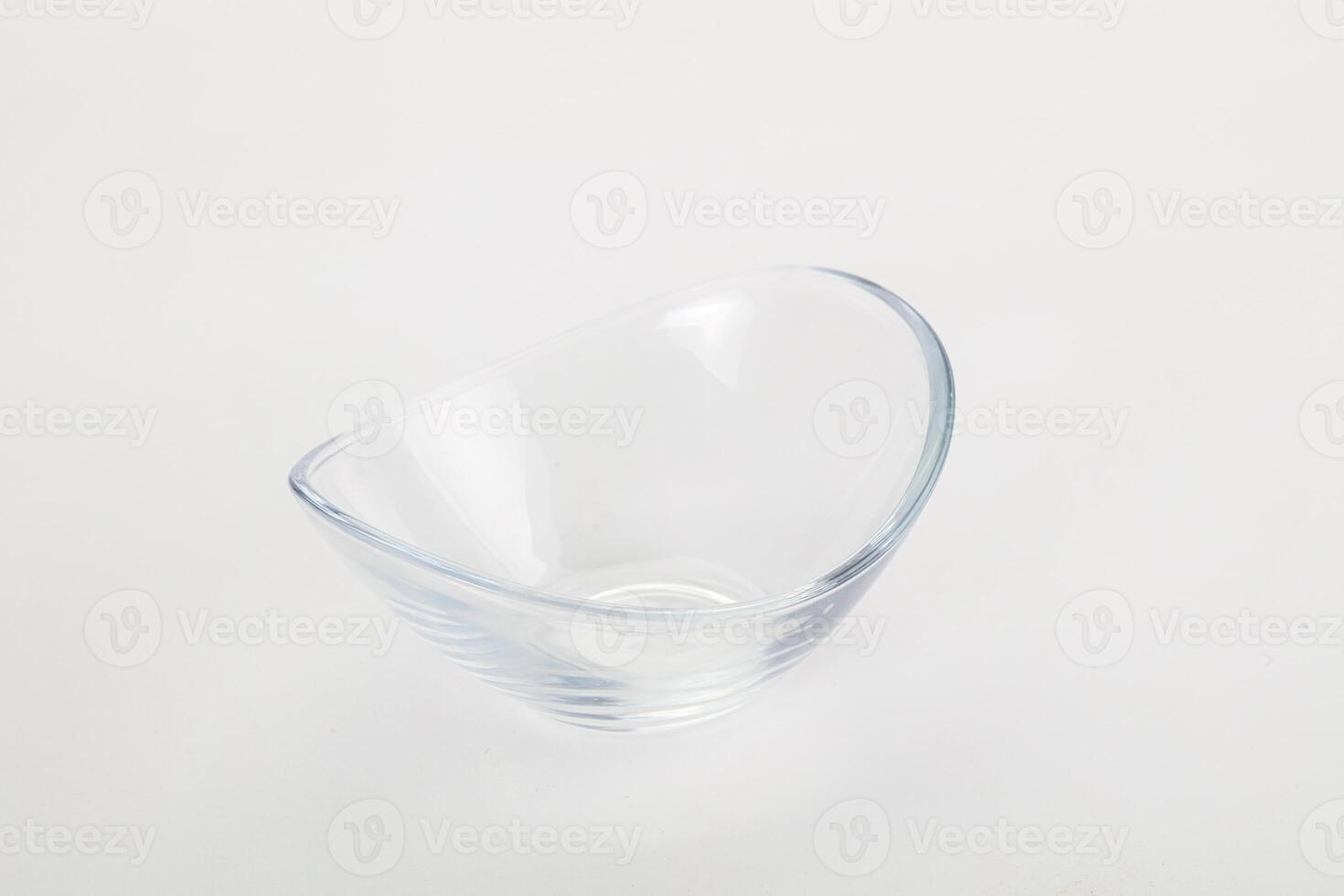 A glass bowl with a curved edge on a white surface photo