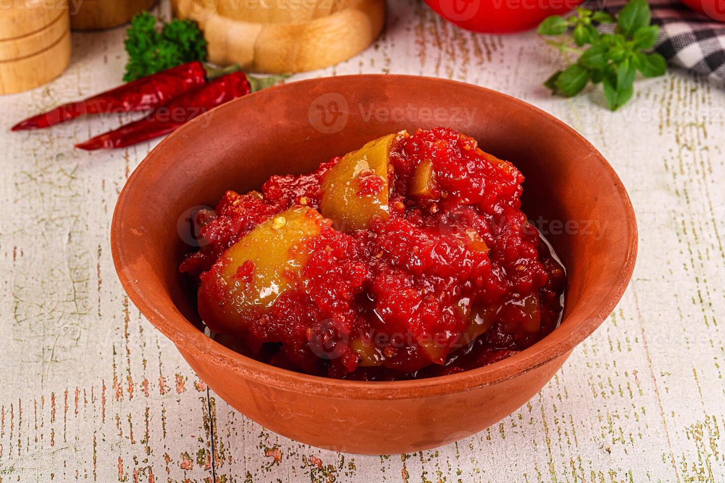 A bowl of tomato sauce with a tomato and a pepper photo