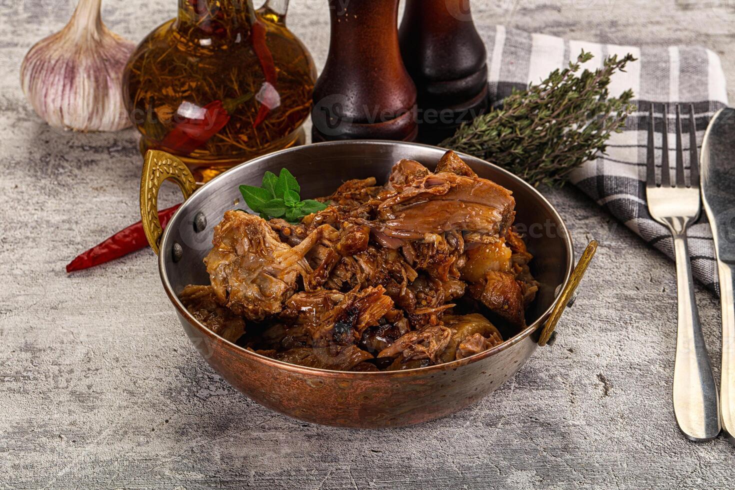 A bowl of meat and vegetables on a table photo
