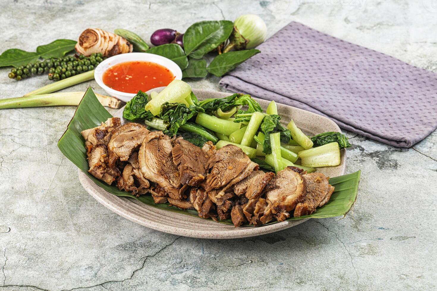 A plate with meat, vegetables and sauce photo